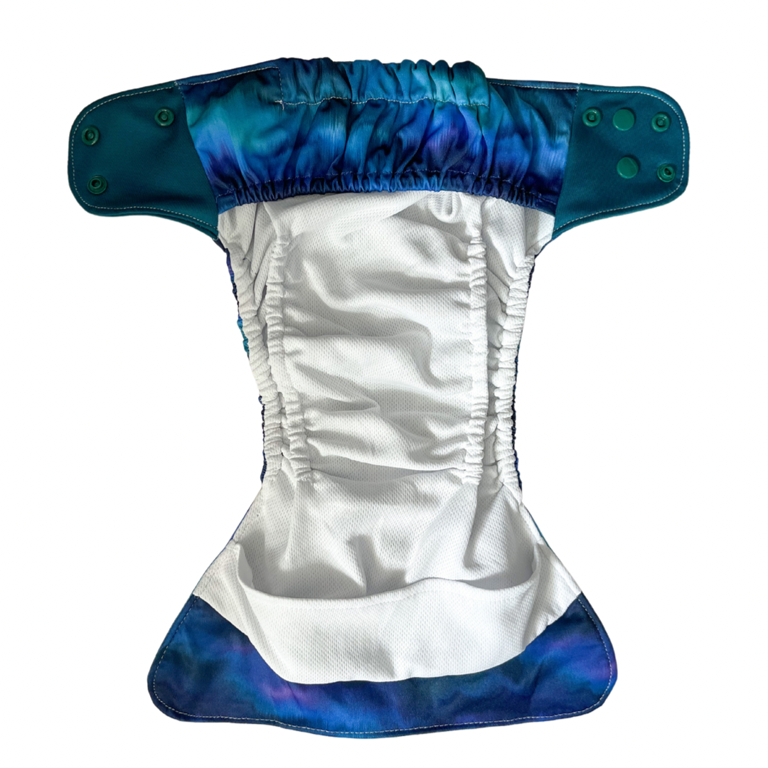 Reusable nappy with stay dry lining, internal double gussets and front and back leak guards.